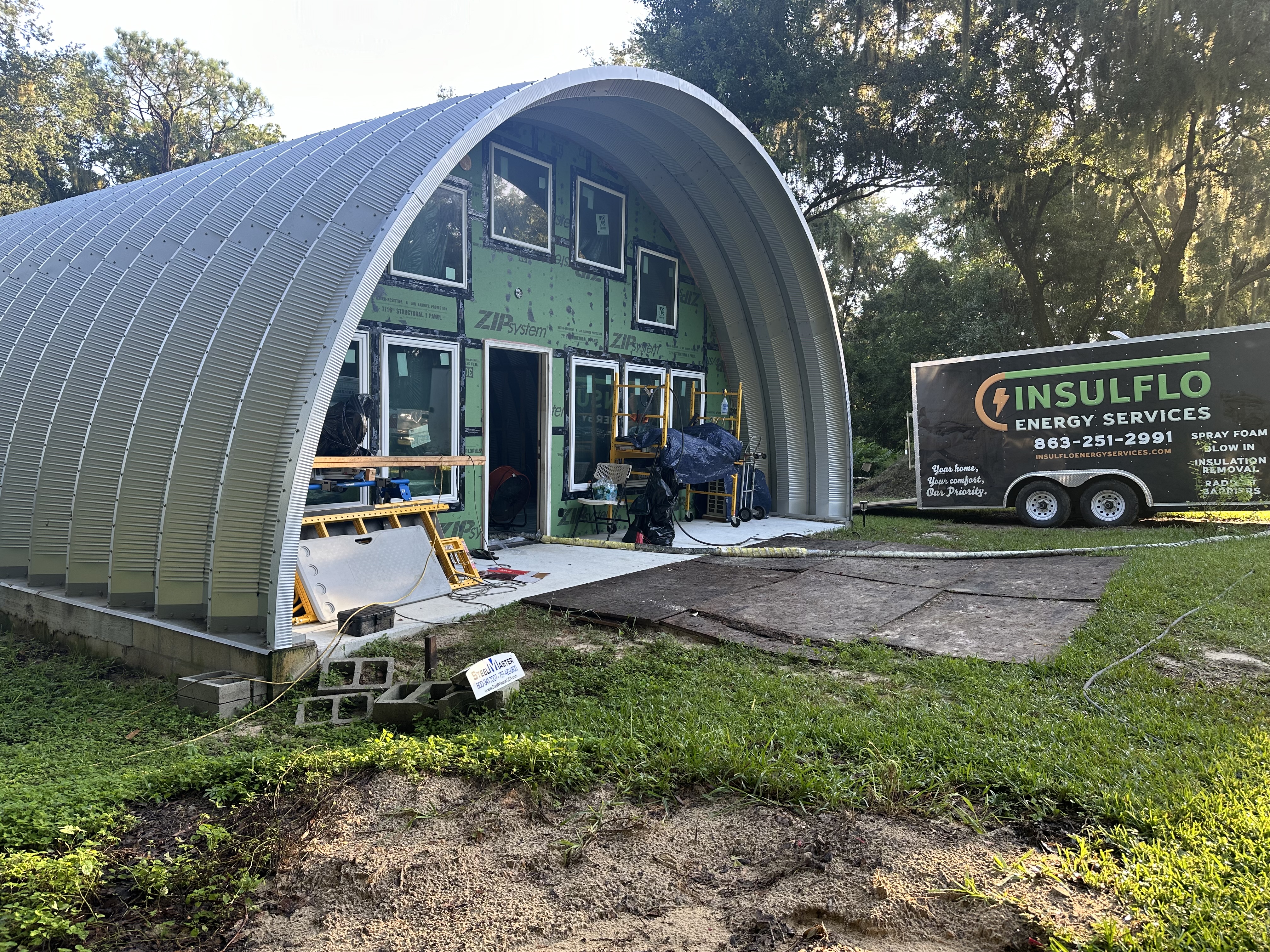Insulflo work trailer parked at a barn jobsite