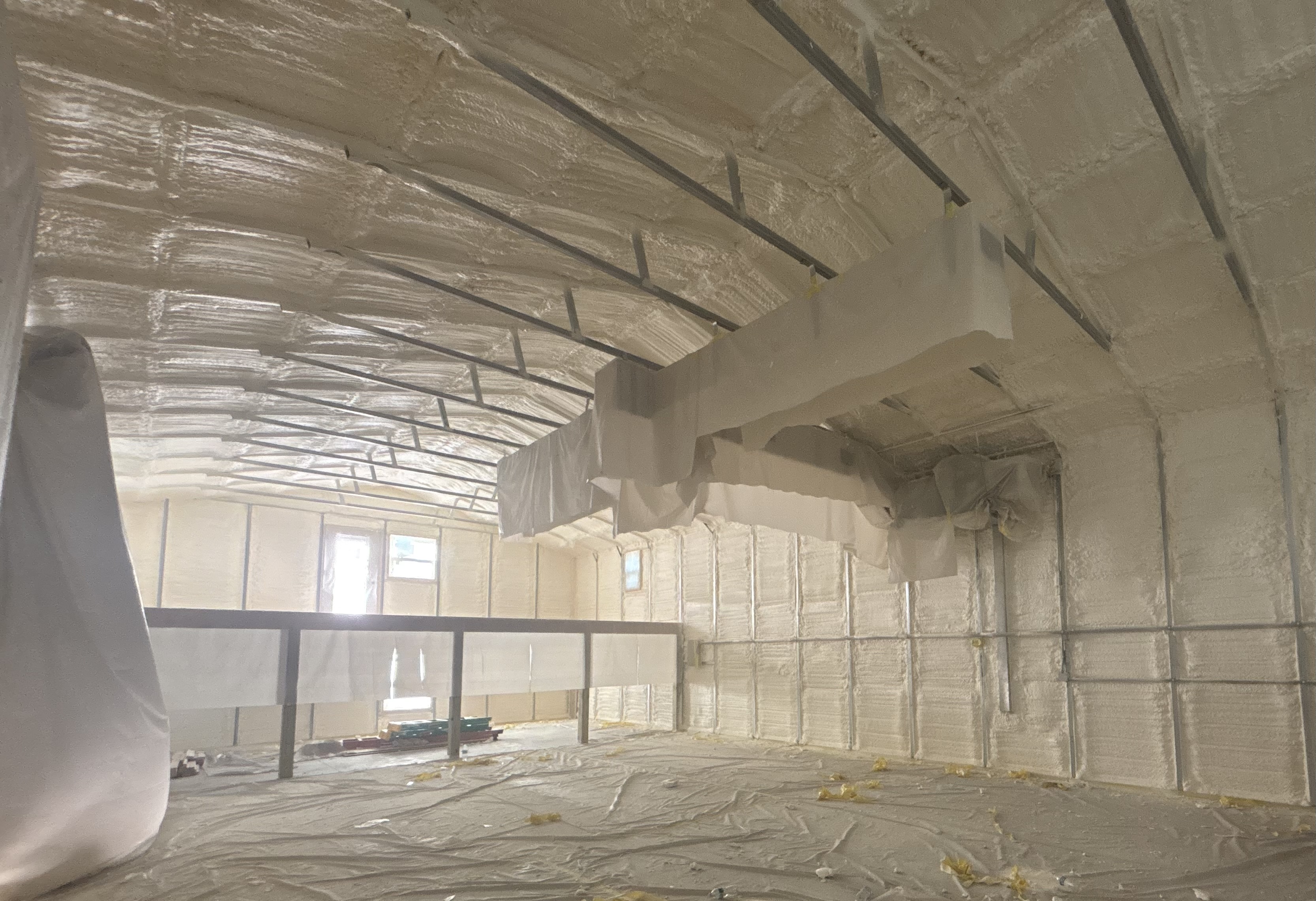 Closed-cell spray foam expanding into wall cavities